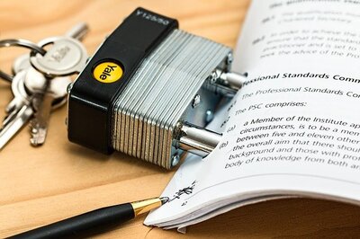 Photo of a Yale lock, with keys, attached to the left edge of a thick binding contract. An open pen rests on the edge of the contract.