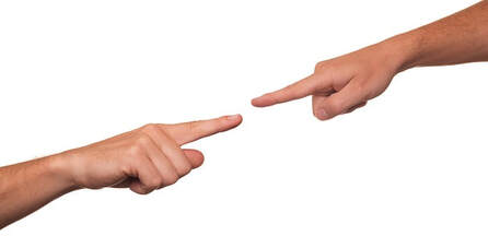A picture of two index fingers (from different people) pointing at each other